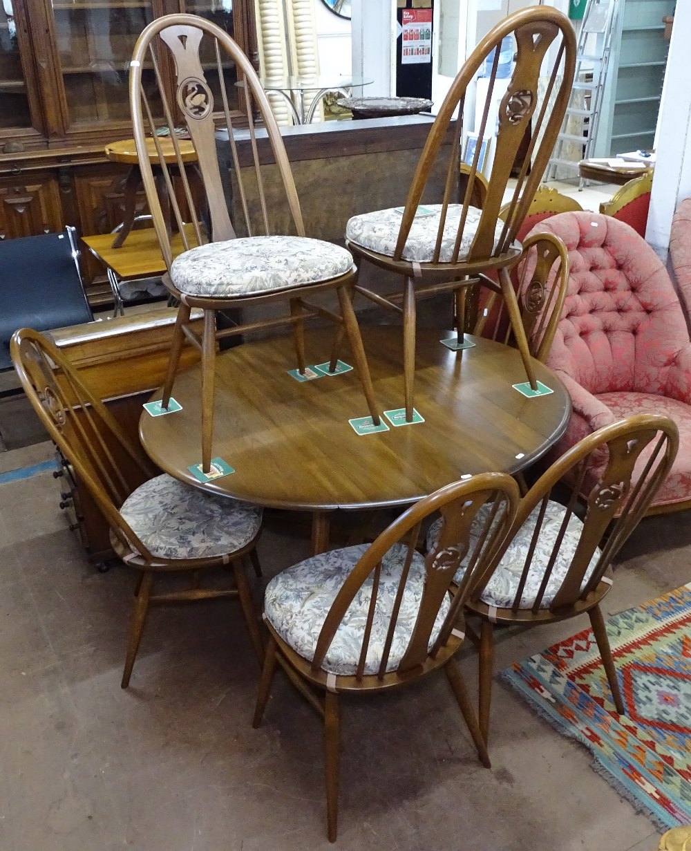 An Ercol elm drop leaf dining table, 125cm extended length, together with a set of 6 matching