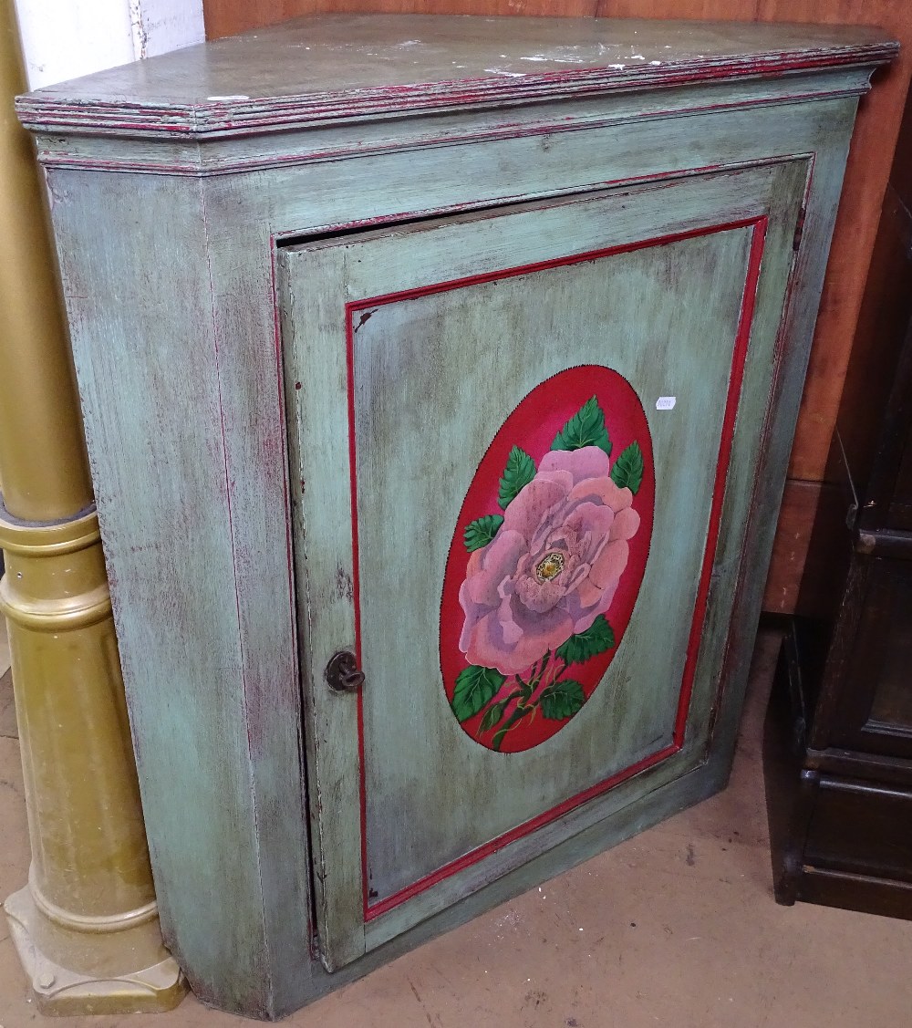 An Antique painted hanging corner cupboard, with shaped shelves and panelled door, W85cm