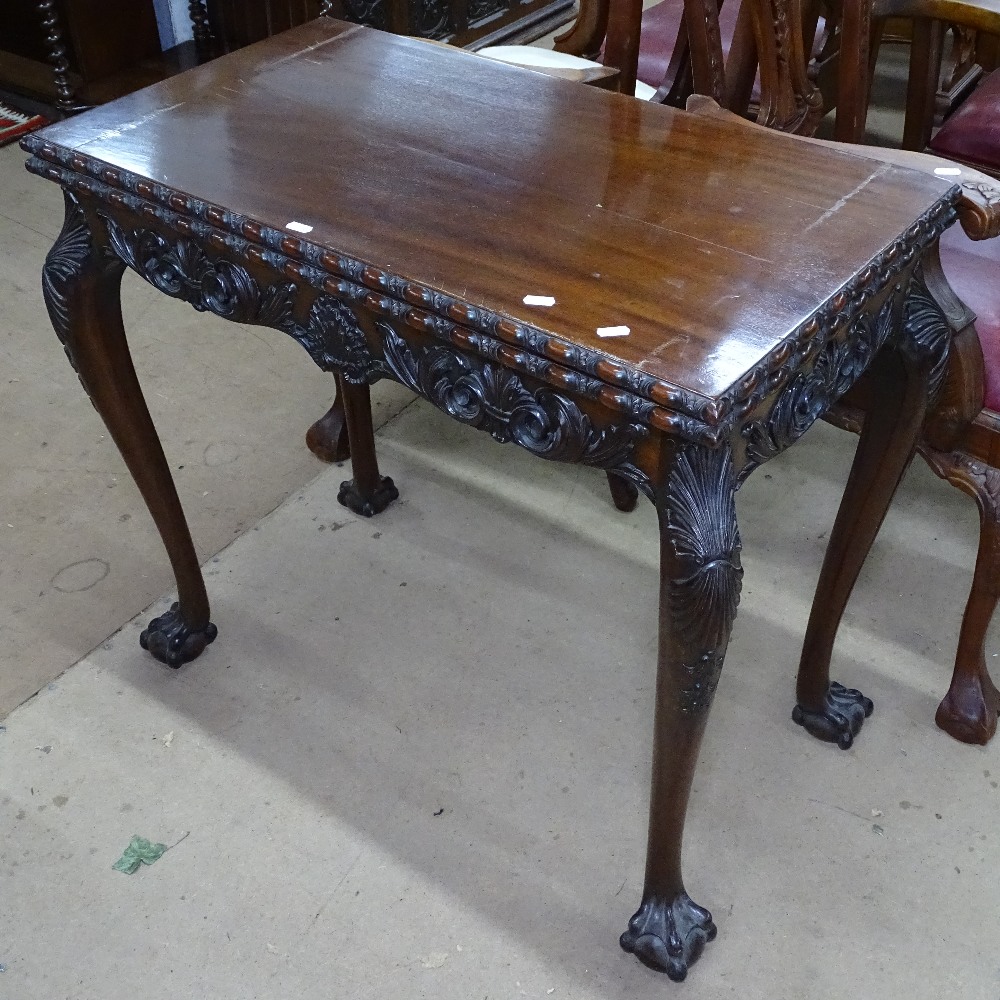 A mahogany rectangular foldover card table, with carved edge and frieze, raised on cabriole legs