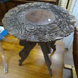 A relief carved hardwood occasional table on folding base, W50cm, H56cm