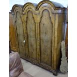 A 1930s figured walnut dome-top 3-door wardrobe, W180cm, H194cm