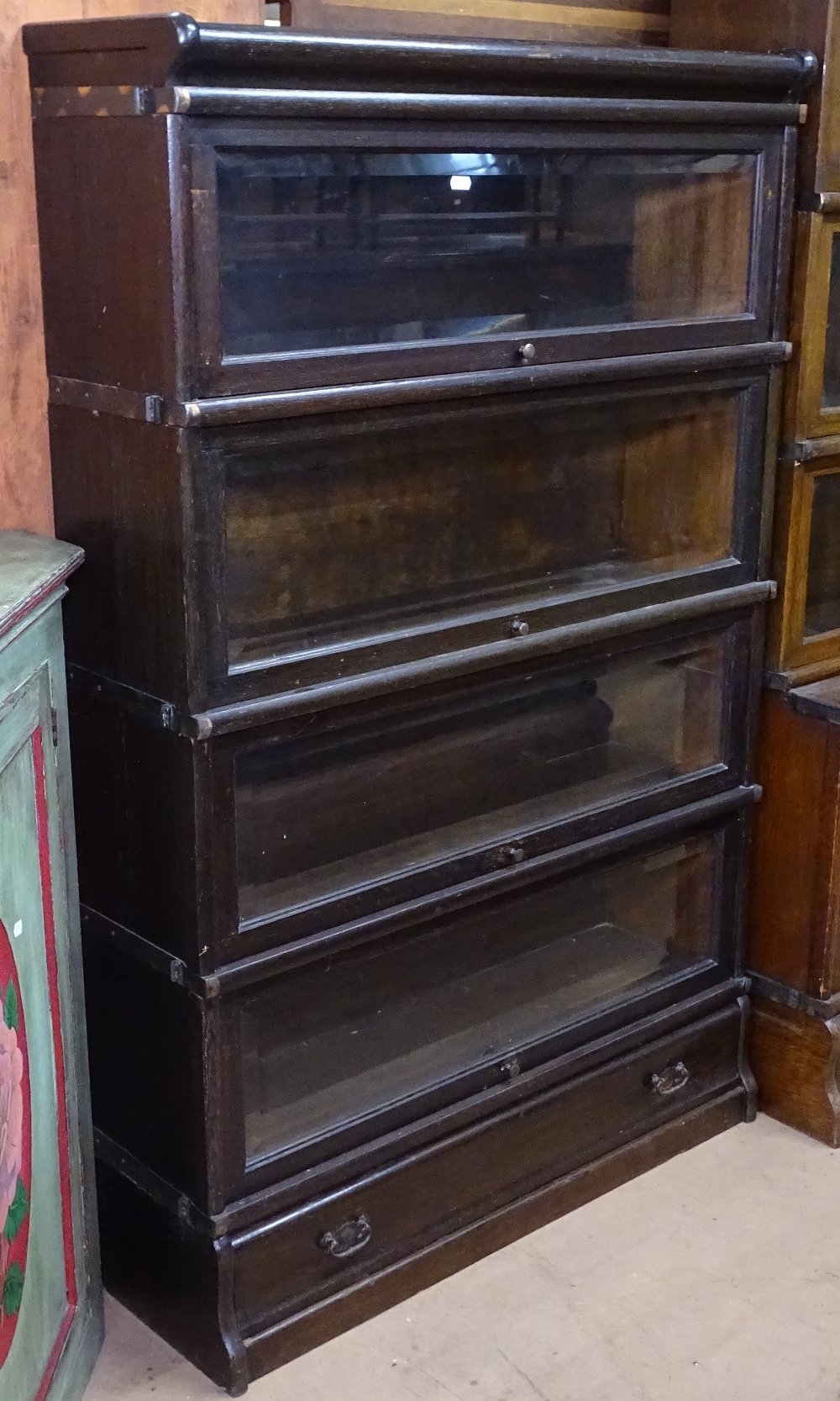 An early 20th century oak 4-section Globe-Wernicke bookcase, with bevelled-glass panels and drawer