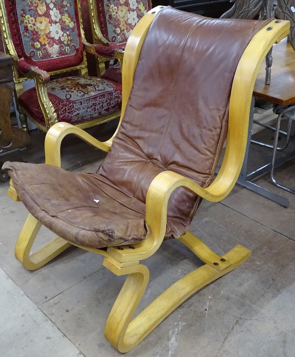 A curvaceous Scandinavian ply-framed lounge chair, with leather upholstery