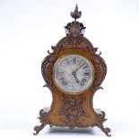 A late 19th century mantel clock with allover ornate cast-brass moulding and mounts, engraved