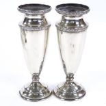 A pair of George V silver urn vases, relief foliate borders, by Joseph Gloster Ltd, hallmarks