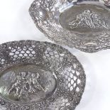 2 German silver bonbon baskets, pierced borders with relief embossed central cherub panels,