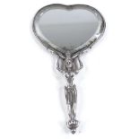 An Indian unmarked silver heart-shaped hand mirror, cast deity handle supporting a heart-shaped