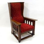 An Arts and Crafts wing-back armchair, attributed to Leonard Wyburd for Liberty, on platform