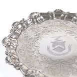 A George II circular silver salver, scalloped foliate and shell rim with floral engraved centre