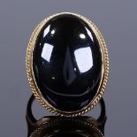 A large 9ct gold onyx panel dress ring, ropetwist surround and openwork shoulders, hallmarks