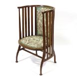 An Arts and Crafts tub chair in the manner of CFA Voysey, with curved slatted back and curved