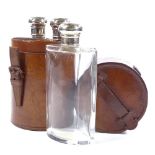 A set of 3 cut-glass silver-topped spirit bottles in original cylindrical leather case, hallmarks