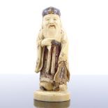A Japanese carved and painted ivory okimono depicting a Sage, late 19th/early 20th century, signed