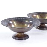 A pair of Edwardian circular silver pedestal dishes, with beaded rims, by Goldsmiths &