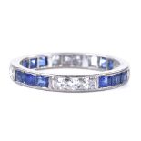 An unmarked white metal sapphire and diamond eternity ring, alternating trios of square-cut