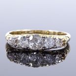 An unmarked gold graduated 5-stone diamond half-hoop ring, scrollwork bridge and shoulders, total