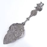 A German silver slice, relief embossed interior scene blade with pierced foliate handle and ship