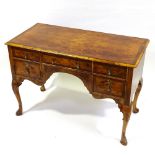 A Georgian style knee-hole desk circa 1900, with quarter veneered top, 5 frieze drawers and carved