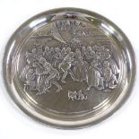 A Birmingham Mint 1975 silver Christmas plate, with relief embossed party scene by V Danks, diameter