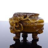A Chinese pot carved from a single piece of tiger's eye, with dragon ring handles and carved