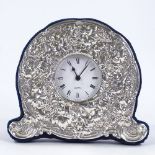 A modern silver-fronted quartz desk clock, relief embossed grapevine and cherub decoration, maker'