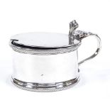 A George V silver mustard pot, gadrooned border with thumb-piece and blue glass liner, by Edward