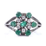 An unmarked white metal emerald and diamond cluster snowflake ring, total diamond content approx 0.