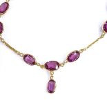 An unmarked gold rhodolite garnet line bracelet, with central garnet drop, bracelet length 20cm, 4.