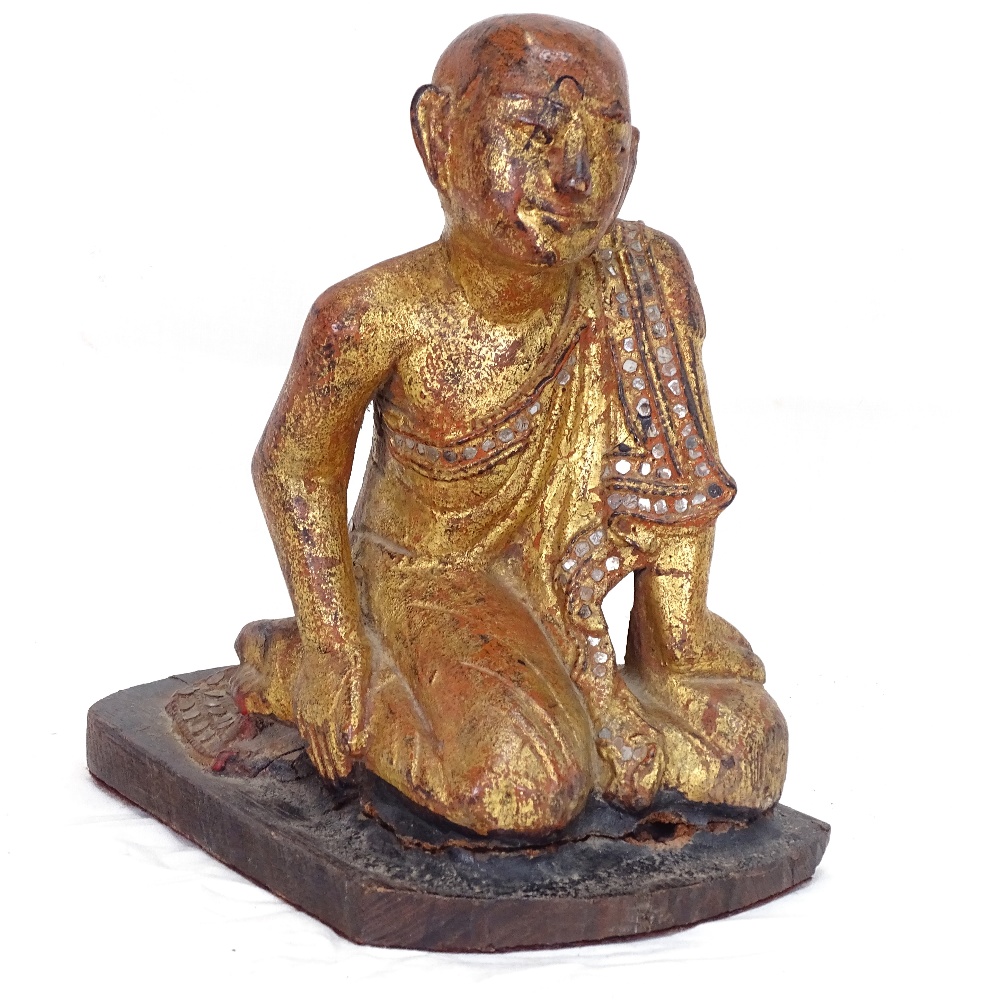 A Buddhist carved painted and giltwood kneeling monk figure, height 21cm