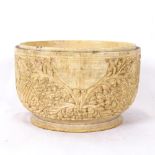 A carved and polished circular ivory pot, relief foliate Buddha designs, diameter 10cm