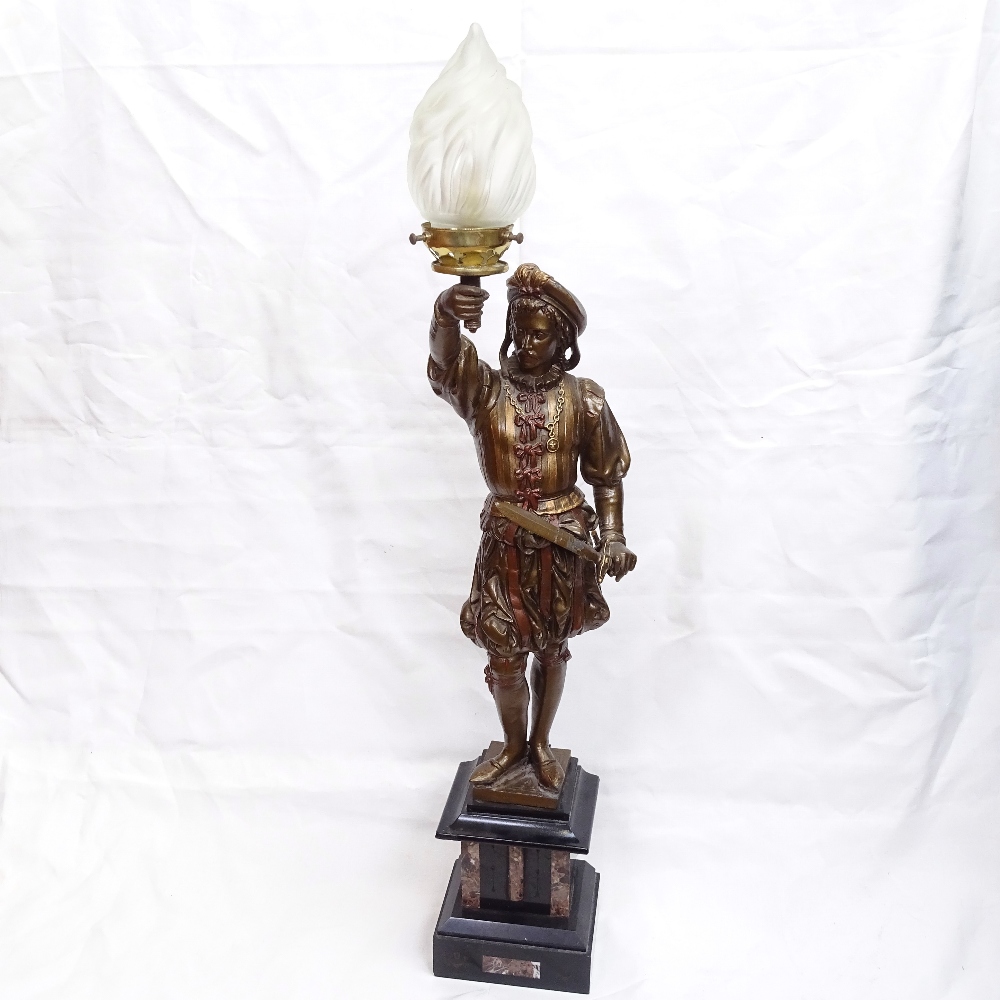 A Renaissance style painted spelter figural lamp sculpture, depicting guard holding flaming torch,