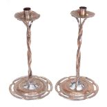 A pair of Arts and Crafts copper table candlesticks, with twisted stems and pierced bases, height