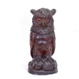 A Black Forest carved and stained wood owl tobacco jar, with inset glass eyes and hinged head,