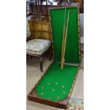 A Victorian mahogany folding bagatelle board, complete with cues and balls