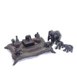 An African carved hardwood elephant desk stand, and 3 graduated elephants, stand length 26cm (4)