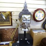 A modern silvered plaster Buddha head sculpture, on square wood stand, overall height 95cm