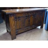 A 1920s oak coffer with linenfold carved panelled front, on stile legs, W99cm, H52cm