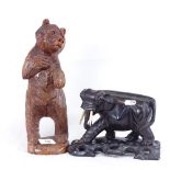 A Black Forest style standing bear carving, and an Oriental carved and stained wood elephant on