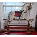 A painted composite rocking horse on teak stand, by Withers & Company England, with brass plaque,