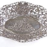 A sterling silver cake basket, relief embossed cherub and floral decoration with pierced cherub