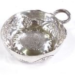 An 18th century French silver wine taster, 1595 coin inset bowl with relief embossed grapevine