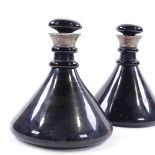 A pair of 19th century dark turquoise glass ship's decanters, with unmarked silver collars, height