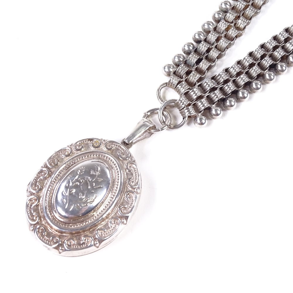 A sterling silver locket necklace, on silver bead collar chain, locket with relief embossed