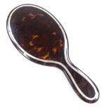 An Edwardian tortoiseshell and silver inlaid dressing table hand mirror, overall length 26.5cm