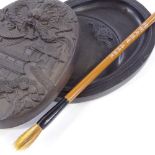 A Chinese ink stone and cover, with relief moulded lid, length 14cm, and brush