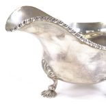 A George V silver sauce boat, gadrooned rim with scrolled acanthus handle and shell feet, by Harrods