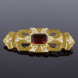 An Art Deco unmarked gold red stone and rose-cut diamond stepped brooch, pierced flared settings,