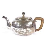 An American Arts and Crafts sterling silver squat teapot, engraved floral decoration with acorn knop