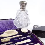 A group of dressing table items, including a leather-cased ivory manicure set, a silver-mounted