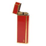 CARTIER - a red lacquer and gilt-metal pocket cigarette lighter